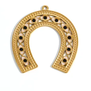 Detailed macro view of a gold-plated stainless steel horseshoe pendant with evil eye motifs