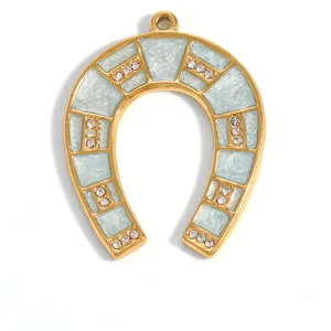 Detailed view of a gold-plated stainless steel horseshoe pendant with blue enamel and crystals.