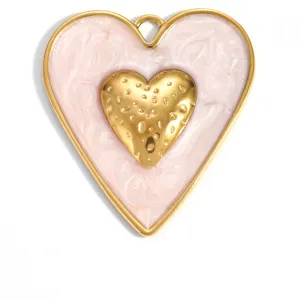 Macro detail view of a pink enamel heart pendant with a golden hammered metal center