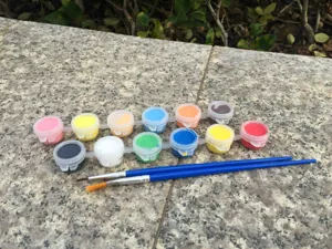 Detailansicht von 12 bunten Acrylfarben im Set mit Pinsel für kreatives Basteln von Kindern.