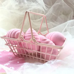 Pink beauty blender sponge set with mini shopping cart prop for makeup application.
