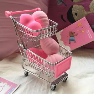 Miniature shopping cart with pink makeup sponges for desktop decor photography props