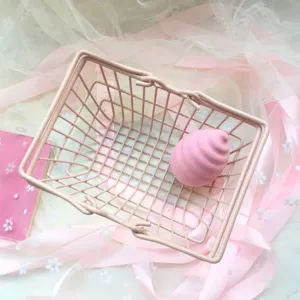 Detailed view of pink mini shopping cart storage basket with beauty egg tray props.