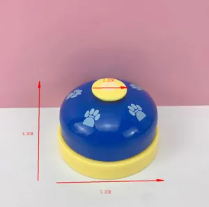 Pet training bell detail shot showing clear blue and yellow body with cute paw print patterns.