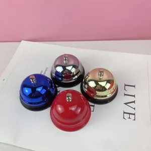 Primer plano detallado de timbres de escritorio de metal colorido con acabado pulido.