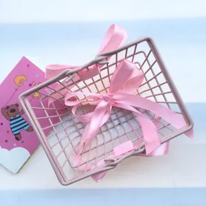 Pink mini shopping cart desktop storage basket with ribbon detail, close-up view.