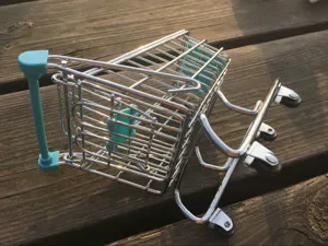 Detail van mini metalen winkelwagentje, bureau opbergmand weergave, creatief tafelblad rekwisiet.