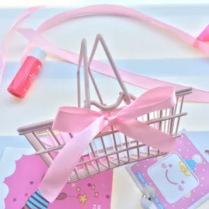 Pink mini shopping cart desktop storage basket with bow detail for makeup sponge display.