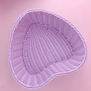 Vue détaillée de la texture et du motif de tissage fin du panier de rangement rose en plastique.