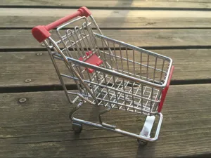 Gedetailleerd close-up van een mini winkelmandje als bureau-organizer op houten oppervlak.