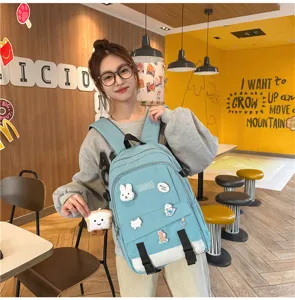 Sac à dos en patchwork bleu clair et blanc avec des badges mignons pour étudiants