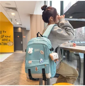 Sac à dos bleu clair décontracté avec patchs de dessins animés et breloques en peluche.