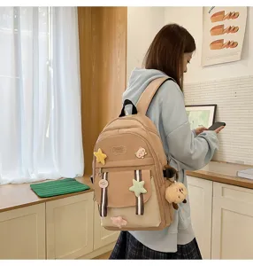 Detail eines beigen Patchwork-Schulrucksacks für Mädchen mit süßen Sternen und Anhängern