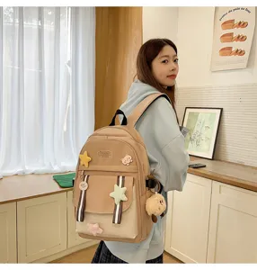 Asiatisches Model trägt einen großen beigen Campus-Rucksack mit süßen Plüschsternen und Bär