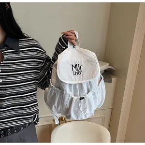 Detailansicht eines weißen Nylon-Rucksacks mit Kordelzug und MUTING-Stickerei Logo