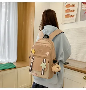 Rückansicht eines funktionalen beigen Schulrucksacks für Mädchen mit süßen Ansteckern.