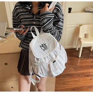 Detailansicht eines weißen Nylon-Rucksacks mit Kordelzug, getragen in lässiger Umgebung