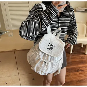 Nahaufnahme eines weißen Nylon-Rucksacks mit Kordelzug, MUTING-Logo und Seitentaschen