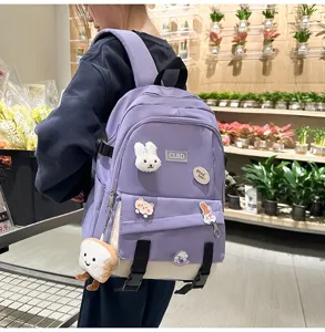 Vue détaillée du sac à dos scolaire violet et blanc avec accessoires mignons.