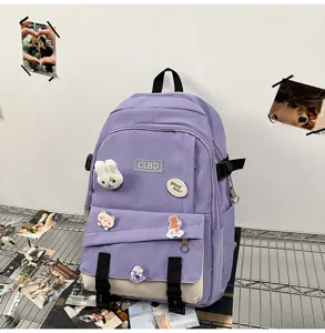 Vue détaillée d'un sac à dos scolaire tendance en patchwork violet et beige avec pins
