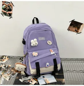 Vue détaillée d'un sac à dos patchwork violet et beige avec des badges et un charme de pain