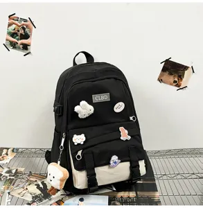 Gros plan d'un sac à dos contrasté noir et crème avec des badges mignons et un porte-clés