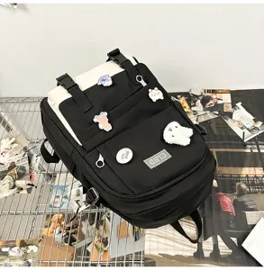 Sac à dos étudiant noir et crème avec des badges mignons sur fond lifestyle