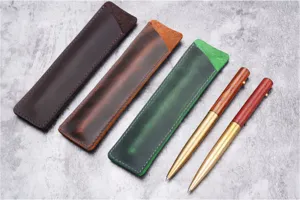 Vue détaillée d'étuis à stylos en cuir faits main et de stylos à bille en bois métal.