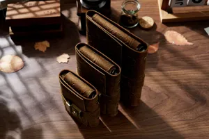 Detailed shot of vintage embossed leather journal notebooks with metal locks on desk.