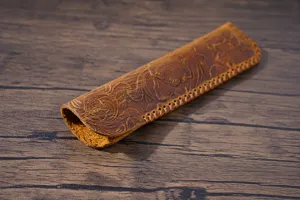 Close-up view of vintage embossed leather pen sleeve, showing detailed tooling craftsmanship.