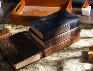 Handmade vintage leather notebook detail showing fine stitching and embossed floral cover texture.