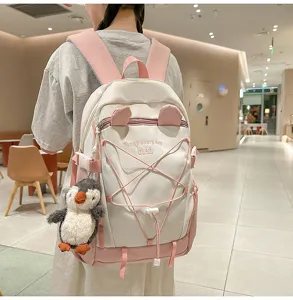 Detailansicht des weiß-rosa Rucksacks mit Katzenohren und Pinguin-Anhänger