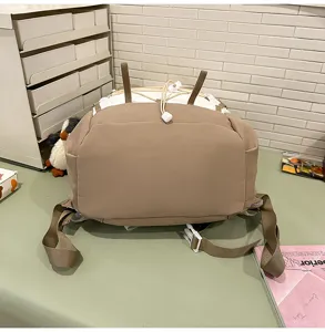 Detaillierte Rückansicht eines khakifarbenen und weißen Wanderrucksacks auf einem Schreibtisch