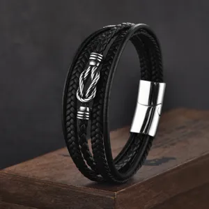 Gros plan d'un bracelet punk multicouche en cuir tressé pour homme avec fermoir en inox.