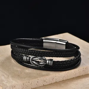 Gros plan de bracelet multicouche en cuir pour homme avec détail de nœud en acier
