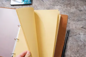 Primo piano di un raccoglitore A4 in pelle vintage con pagine gialle spesse per schizzi