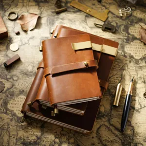 Vue détaillée du carnet de notes en cuir véritable vintage avec pinces en métal et fermeture sangle.