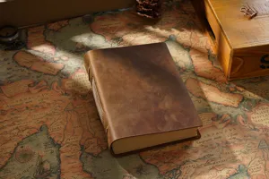 Leather notebook detail showing vintage handmade brown genuine leather cover and binding texture.