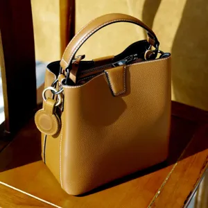 Vista dettagliata di una borsa a secchiello in pelle marrone con cuciture e finiture.