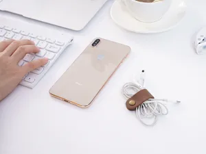 Détail d'organisateur de câble en cuir véritable marron, enrouleur à bouton-pression.
