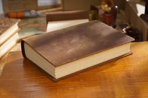 Close-up detail of vintage handmade genuine leather notebook with rustic brown cover and thick pages.