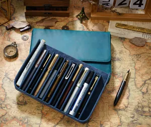 Astuccio per penne a 12 scomparti in vera pelle, dettaglio con cancelleria su mappa vintage.