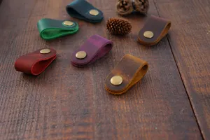 Gros plan d'organisateurs de câbles en cuir véritable coloré et enrouleurs sur bois.