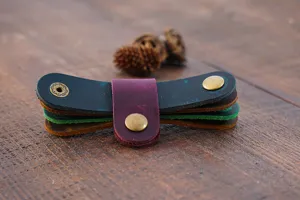 Gros plan détaillé d'organisateurs de câbles en cuir véritable avec boutons métalliques.