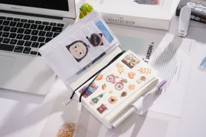 Nahaufnahme der weißen Litschi-Muster Leder A6 Planer Notizbuchhülle mit süßen Stickern.