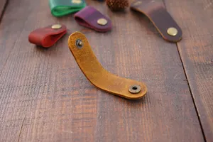 Organisateur de câble en cuir de vachette véritable avec bouton-pression pour écouteurs.