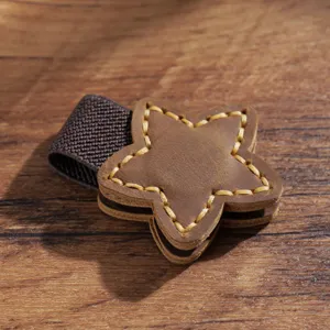 Primo piano dettagliato di un segnalibro magnetico in pelle marrone a stella.