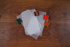 Transparante matte ringbandverdelers met kleurrijke lederen penlussen voor planners.