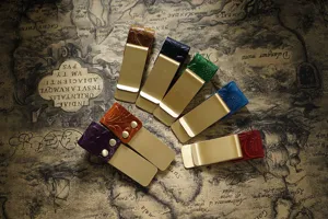 Detailed view of vintage embossed leather brass metal pen clips and money clips for notebooks.