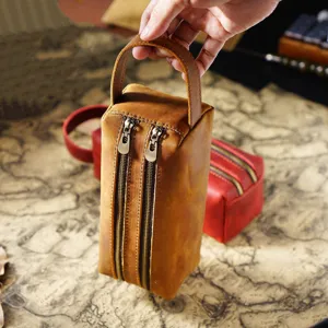 Close-up of genuine leather double zipper pencil pouch with handle, vintage style.